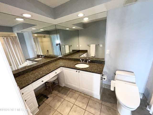 bathroom featuring vanity, tile patterned floors, and toilet
