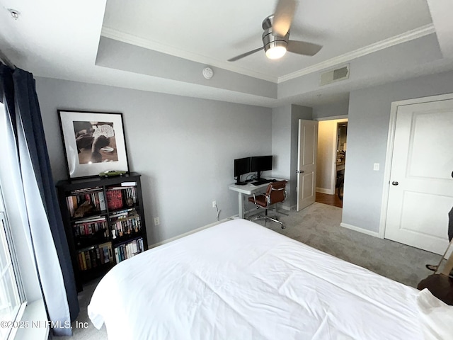 carpeted bedroom featuring crown molding, ceiling fan, and a tray ceiling