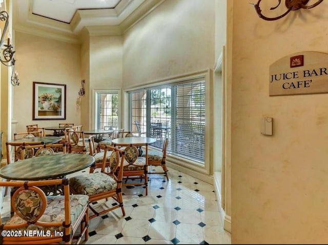 dining area featuring ornamental molding and a high ceiling