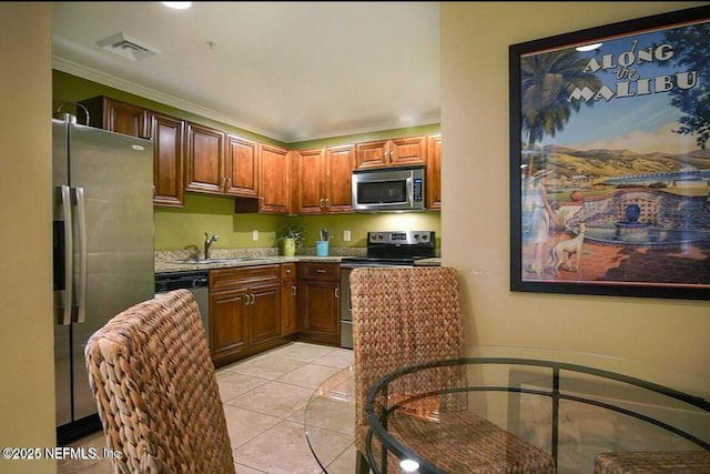 kitchen featuring ornamental molding, appliances with stainless steel finishes, sink, and light tile patterned flooring