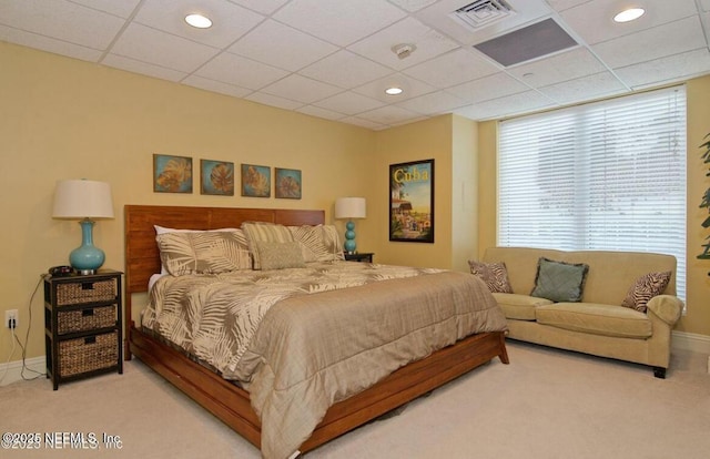 carpeted bedroom featuring a drop ceiling