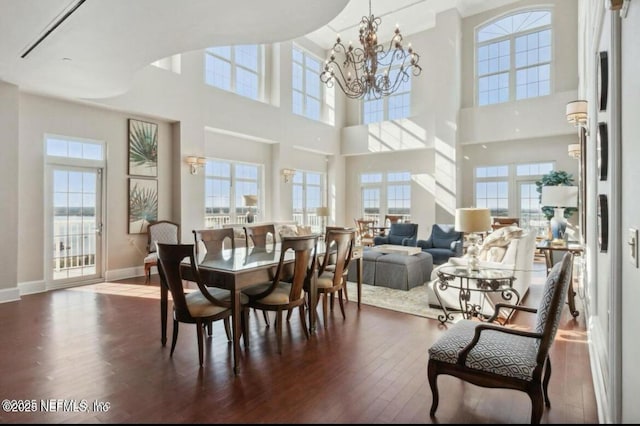 dining area with a notable chandelier, dark wood-type flooring, and a healthy amount of sunlight