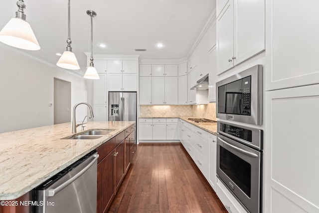 kitchen with white cabinetry, appliances with stainless steel finishes, sink, and a center island with sink