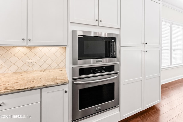 kitchen featuring built in microwave, white cabinetry, and oven