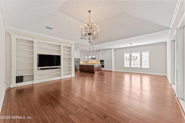 unfurnished living room with an inviting chandelier, hardwood / wood-style floors, ornamental molding, and lofted ceiling