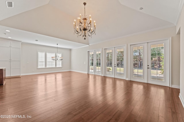 unfurnished living room featuring wood-type flooring, ornamental molding, an inviting chandelier, and french doors