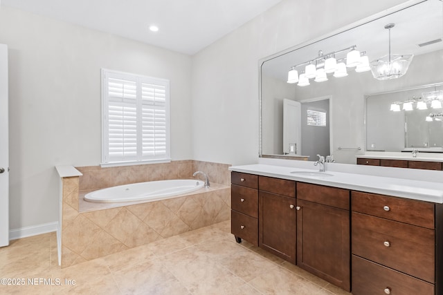 bathroom featuring tile patterned floors, vanity, and tiled bath