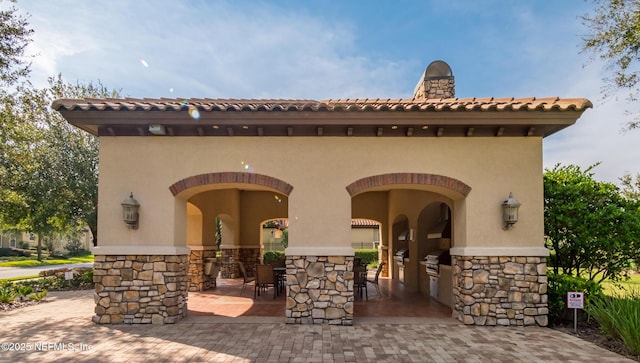 exterior space with an outdoor kitchen and grilling area