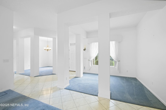 carpeted spare room with an inviting chandelier