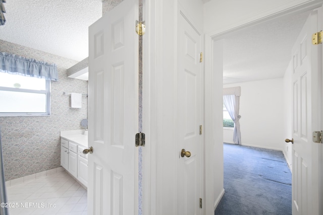 bathroom with vanity, a healthy amount of sunlight, and a textured ceiling