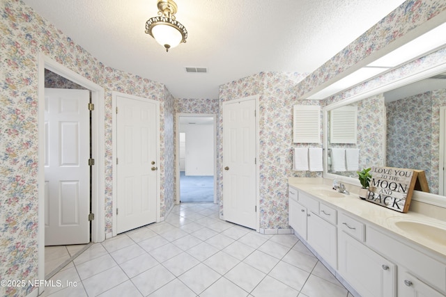 bathroom featuring tile patterned floors, a textured ceiling, and vanity