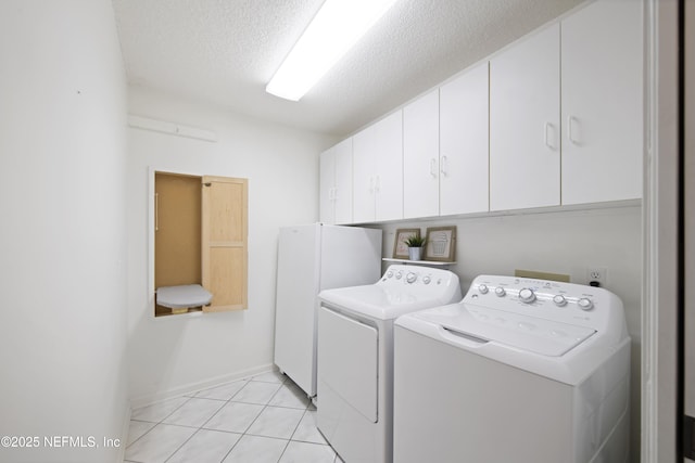 laundry area with separate washer and dryer, light tile patterned floors, cabinets, and a textured ceiling