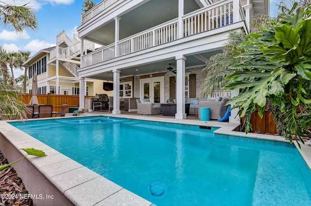 view of pool featuring french doors, an outdoor bar, ceiling fan, an outdoor living space, and a patio