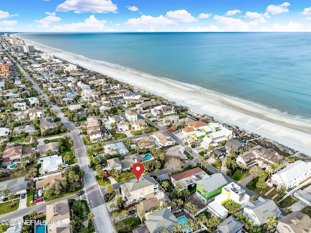 birds eye view of property with a water view and a beach view