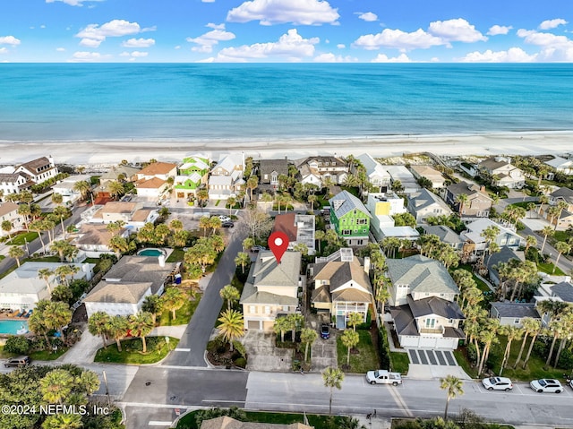 drone / aerial view featuring a water view and a view of the beach