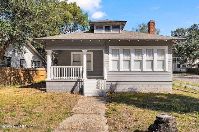 bungalow-style house featuring covered porch and a front lawn