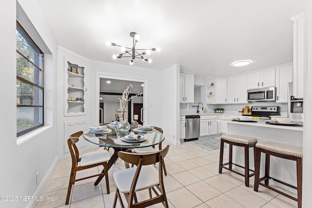 dining area featuring sink, light tile patterned floors, and a chandelier