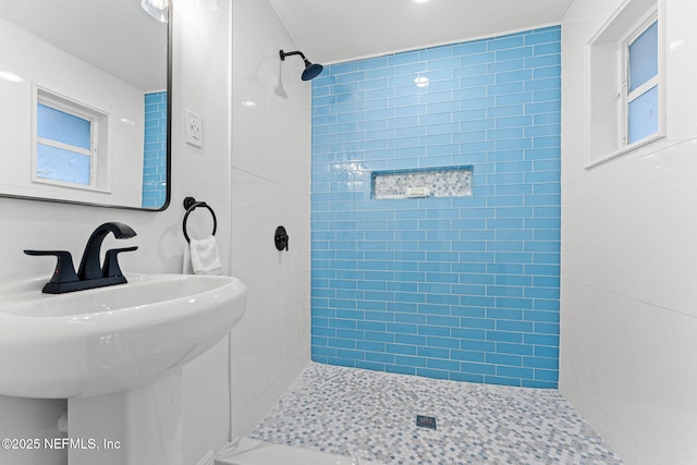 bathroom featuring sink and a tile shower