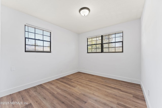 unfurnished room with hardwood / wood-style flooring