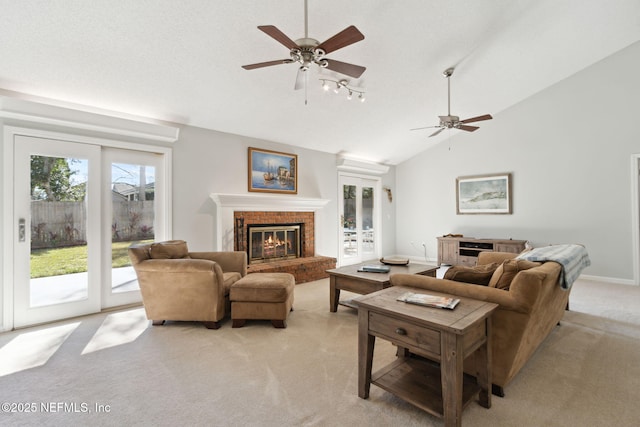 carpeted living room with a fireplace, ceiling fan, and high vaulted ceiling