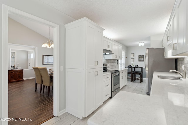 kitchen with appliances with stainless steel finishes, sink, white cabinetry, and tasteful backsplash