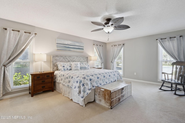 bedroom featuring light carpet, ceiling fan, and a textured ceiling