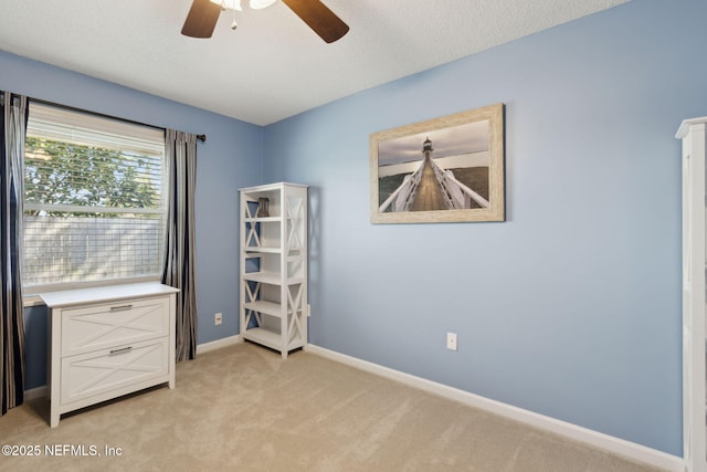 unfurnished bedroom with ceiling fan, a textured ceiling, and light colored carpet