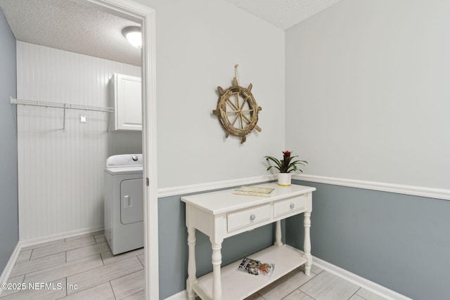 bathroom featuring a textured ceiling and washer / dryer