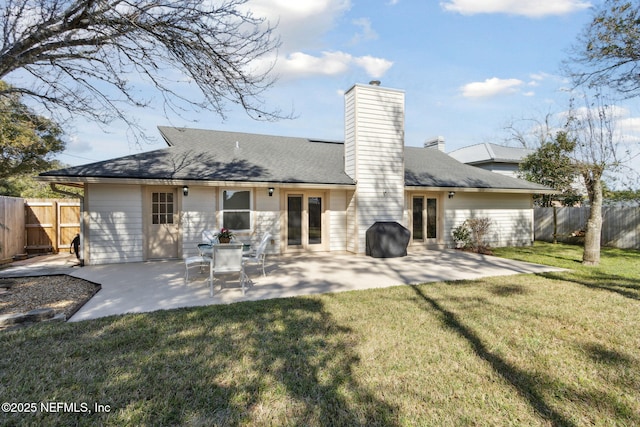 back of house featuring a patio area and a lawn