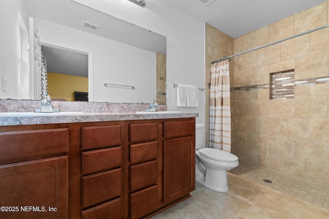 bathroom with vanity, tile patterned floors, toilet, and walk in shower