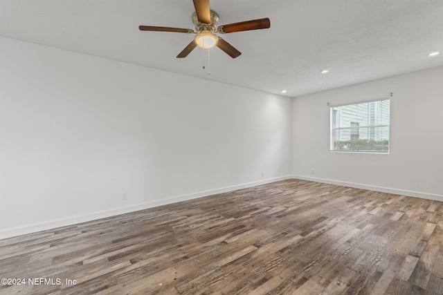 spare room with a ceiling fan, baseboards, wood finished floors, and recessed lighting