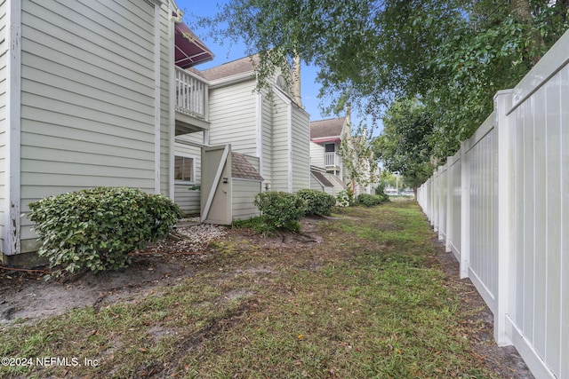 view of yard featuring a balcony and fence