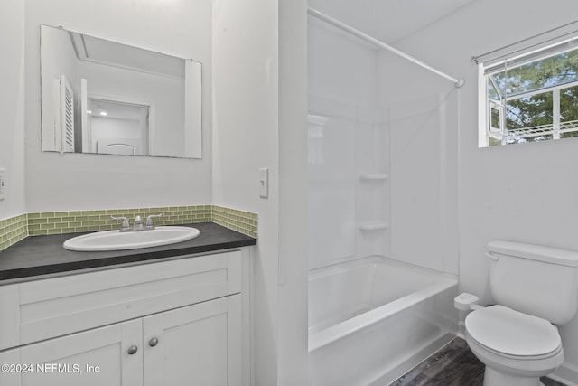 bathroom with bathtub / shower combination, backsplash, toilet, and vanity