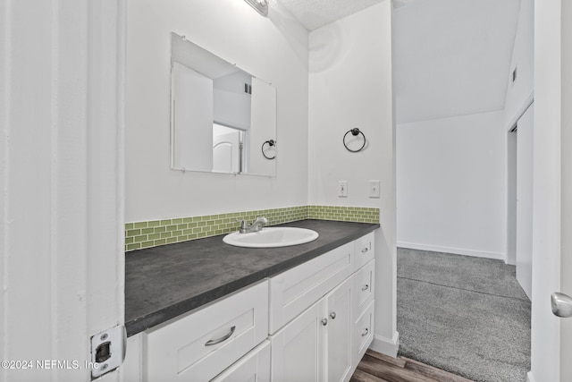 bathroom with baseboards, vanity, and decorative backsplash