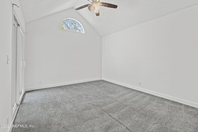 carpeted empty room with lofted ceiling, ceiling fan, and baseboards