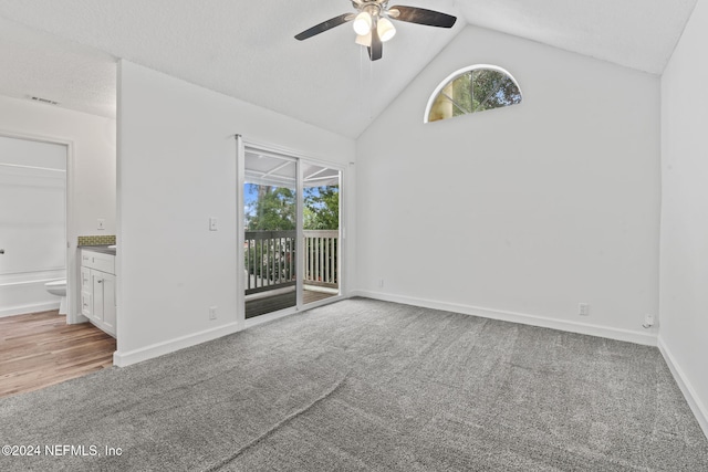 carpeted spare room featuring lofted ceiling, ceiling fan, baseboards, and a textured ceiling