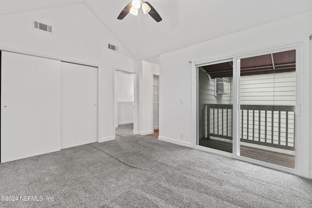 unfurnished bedroom with high vaulted ceiling, carpet flooring, visible vents, and access to exterior