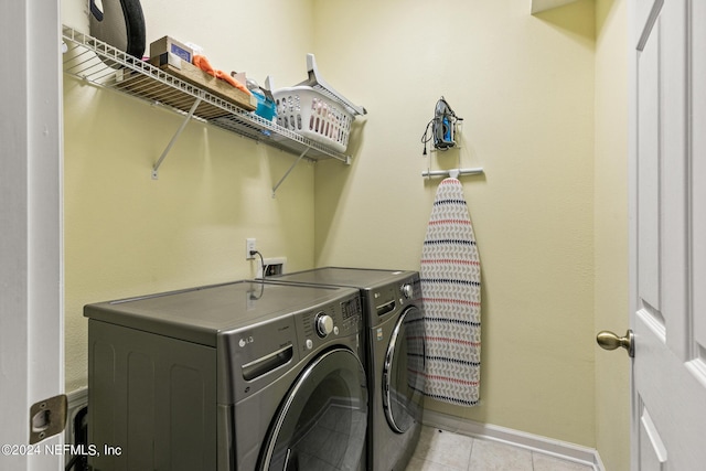 laundry area with washing machine and dryer and light tile patterned floors