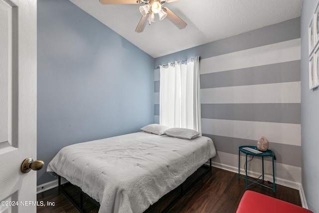 bedroom with ceiling fan, lofted ceiling, and dark hardwood / wood-style floors