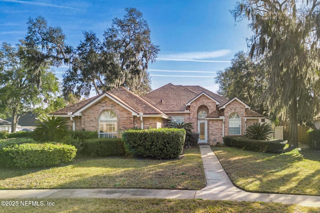 view of front facade featuring brick siding and a front lawn