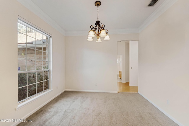 empty room with a chandelier, light colored carpet, crown molding, and baseboards