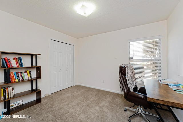 office area with light carpet, a textured ceiling, and baseboards