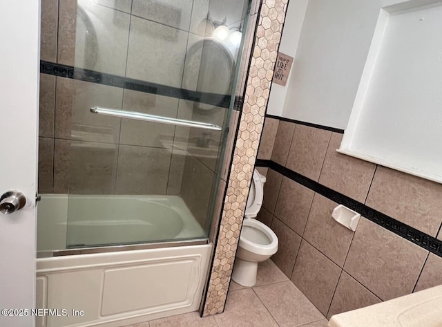 816 Middleton Rd, Jacksonville, FL 32211 - full bathroom featuring bath / shower combo with glass door, tile walls, tile patterned flooring, and a wainscoted wall