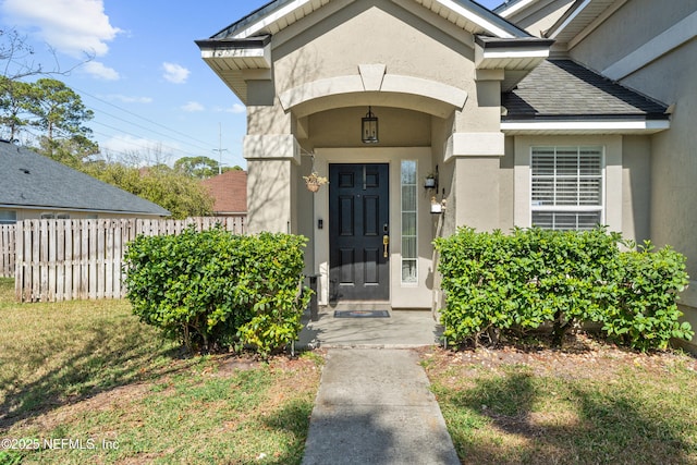 view of exterior entry featuring a lawn