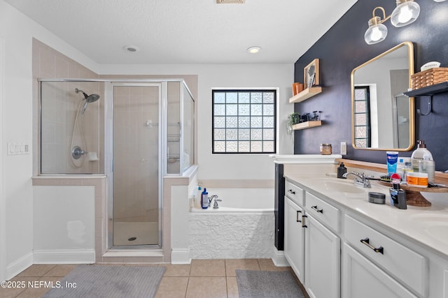 bathroom featuring tile patterned floors, independent shower and bath, vanity, and a textured ceiling