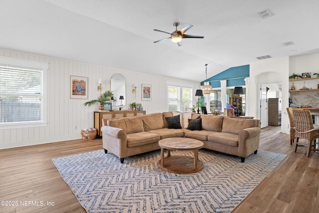 living room featuring ceiling fan, lofted ceiling, and wood-type flooring