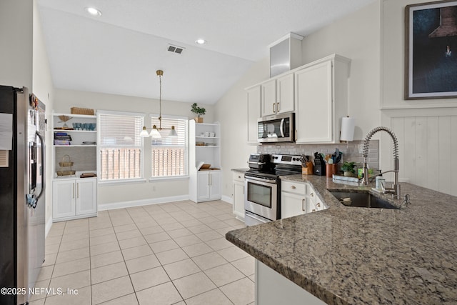 kitchen with stone counters, appliances with stainless steel finishes, sink, and white cabinets