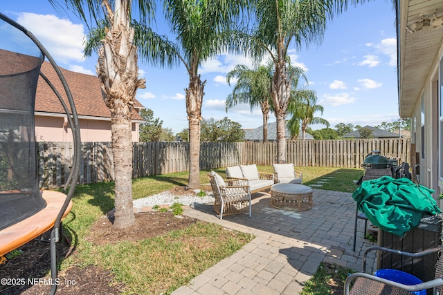 view of patio with a trampoline and an outdoor fire pit