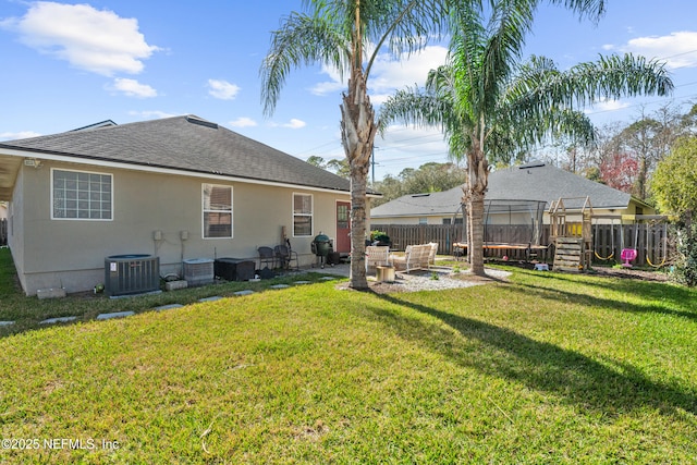 rear view of property featuring a yard and central air condition unit