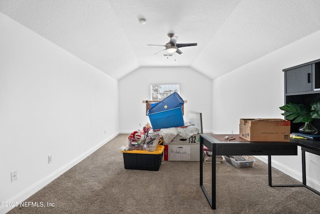 carpeted office featuring vaulted ceiling, ceiling fan, and a textured ceiling